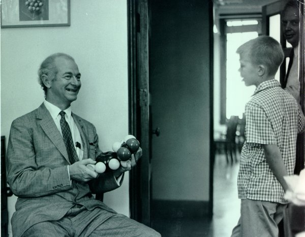 Linus Pauling showing a molecular model to a young boy.