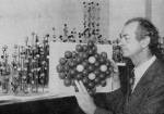 Linus Pauling holding a molecular model depicting the atomic arrangement of metallic alloys.