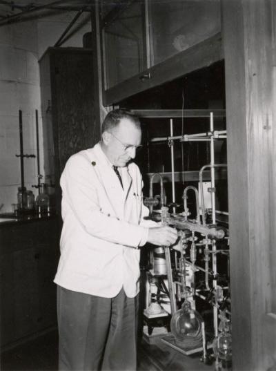 <p>Dr. Joseph Butts, Head of Agricultural Chemistry, adjusting a high vacuum system used to make materials radioactive, ca. 1950s. Butts was a professor of Agricultural Chemistry from 1939-1961 <span class='highlight1 bold'>and</span> Department Head from</p><p>				1946-1961. One focus of his interest was utilizing atomic energy for peaceful means.</p>