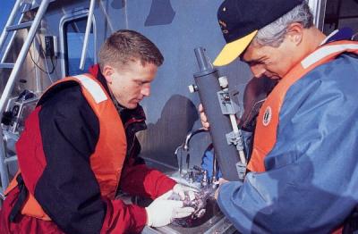 <p>Image from an article titled "Sheer Number" by Carol Savonen. Photo caption reads: "Morris, left, works with Giovannoni to remove water from a metal sampling canister they lowered into the Pacific Ocean. Back on the OSU</p><p>				campus, they'll try to isolate, reproduce <span class='highlight1 bold'>and</span> study microbes in the water sample to learn about their role in ocean ecosystems."</p>
