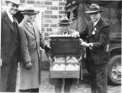 Men in front of the Russell Poultry Building showing baby chicks, ca. 1940s.