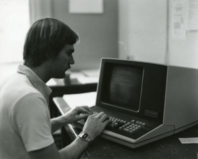 Unidentified individual using an early model desktop computer, 1970s.