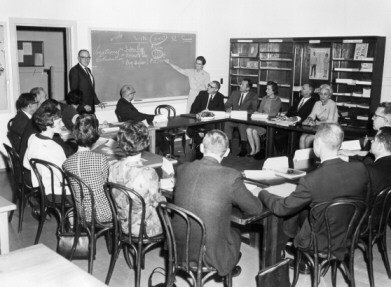 School of Education staff meeting, ca. 1967. Faculty Ted Yerian and Isabella McQueston preside over a planning meeting where the details of a newly established department in the school, the Vocational, Adult, and Community College Division, were being addressed.