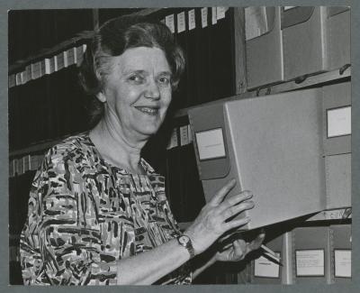 Harriet Moore posing with archival materials, circa 1965
