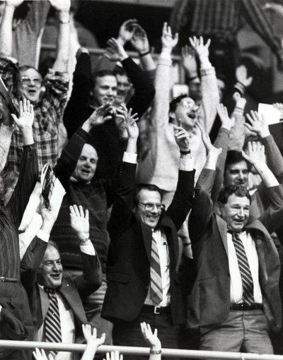 Black and white photograph of John Vincent Byrne doing the &quot;wave&quot; at Gill Coliseum.