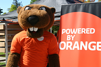 Benny Beaver celebrating Powered by Orange