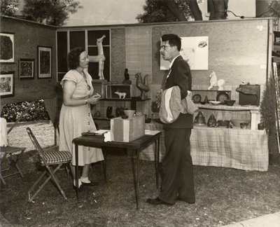 Black and white photograph of Roger Hayward at an outdoor art exhibit.