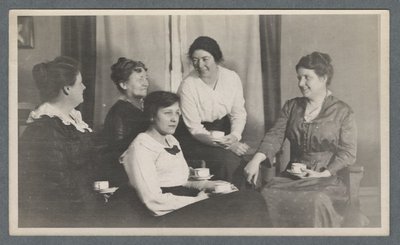 Five women conversing over tea