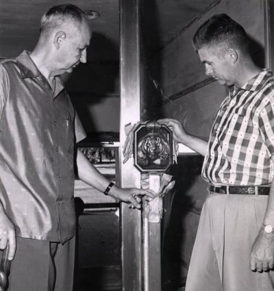 Ed Allworth (left) examining a Beaver door handle at the Memorial Union. Ca. 1950s.