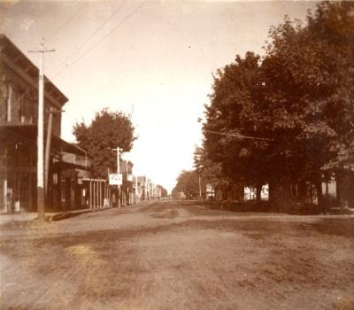 Second street, looking north, before it was paved, ca. 1900. A trolley in the middle of the street is visible in the distance.