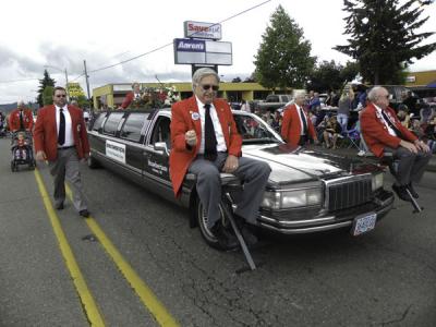 Strawberrians, in their signature red jackets, ride a limo at a parade along Main Street.  Lebanon Strawberry Festival, 2012.