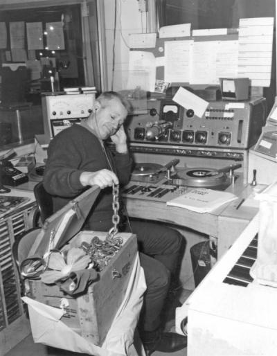 Barney Keep posing with a box of chains, ca. 1960s. Keep worked with KOAC before becoming a famous radio personality for Portland's KEX radio station from 1944-1979.
