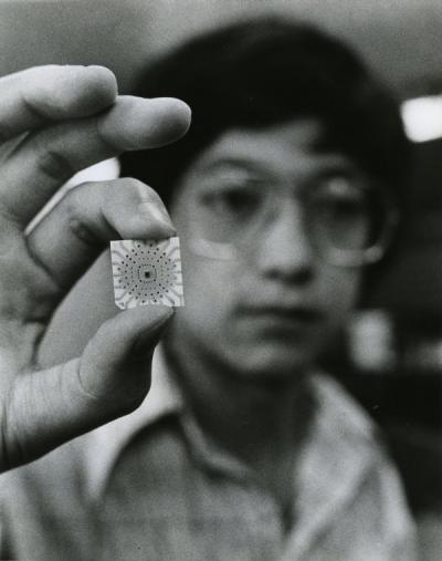An unidentified individual holding a computer chip, ca 1970s.