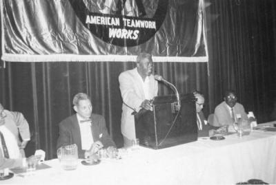 Baseball great Jackie Robinson, speaking at an Urban League of Portland meeting, 1955. Edwin C. Berry, Director of the Urban League, is seated second from left.