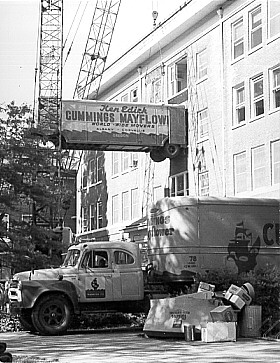 Microbiology Department moving from Agriculture Hall, 1970. The department moved to new quarters in Nash Hall designed specifically for microbiological work. Because Agriculture Hall had no elevator, cranes were used to lift the moving vans to the building's upper floors, where equipment and supplies were loaded onto the vans.