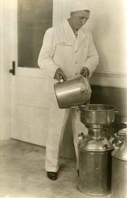 OSC Dairy Department Worker Pouring Milk, ca. 1935