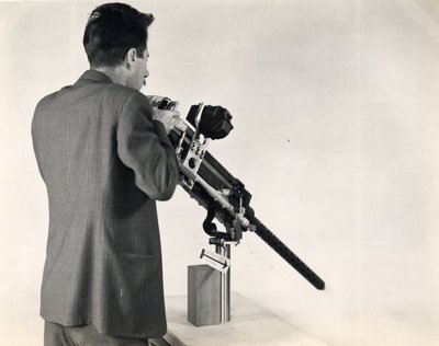 Black and white photographs of Roger Hayward demonstrating the use of a military machine gun.