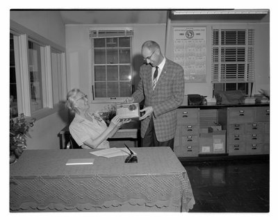 An unidentified OSC Business Office employee photographed receiving a radio as a retirement gift
